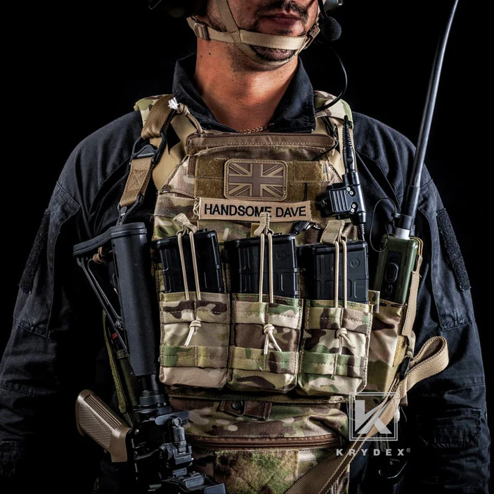 Person wearing a tactical vest with a British flag patch and 'Handsome Dave' text, holding a rifle.