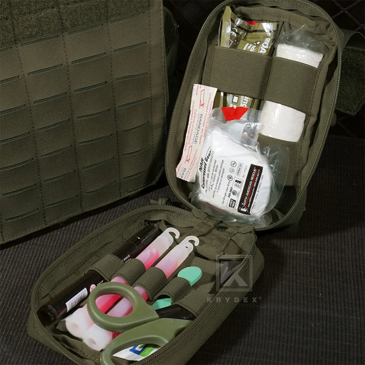 Open green tactical aid pouch containing supplies on a dark textured surface.