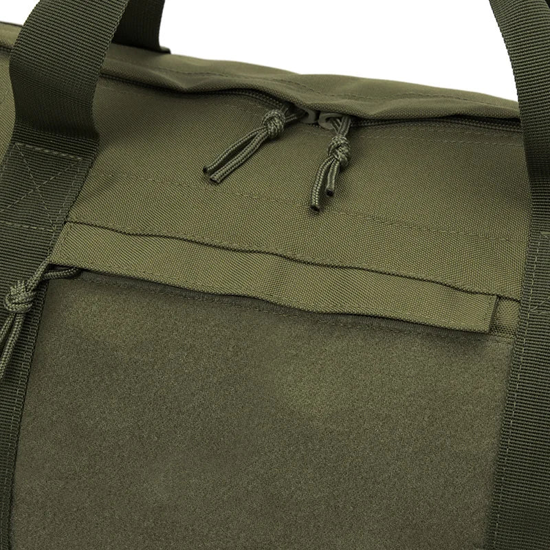 Close-up of a green tactical bag with straps and zippers.