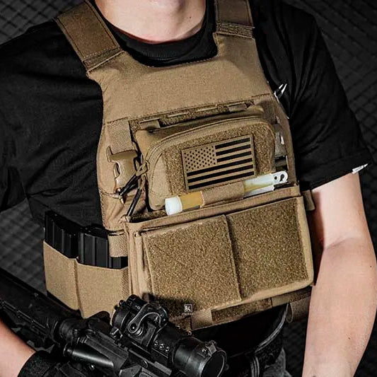 Person wearing a tactical vest with a rifle on a dark background