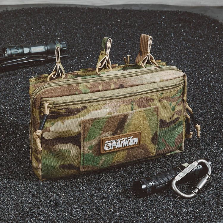 Camouflage pouch with multiple zippers on a dark textured surface.