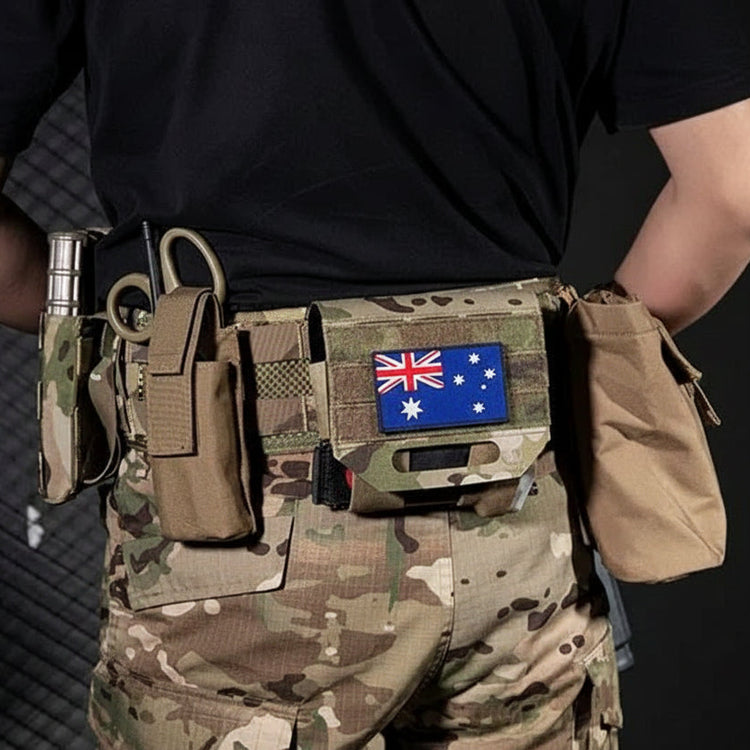 Person wearing a tactical belt with multiple pouches on a dark background