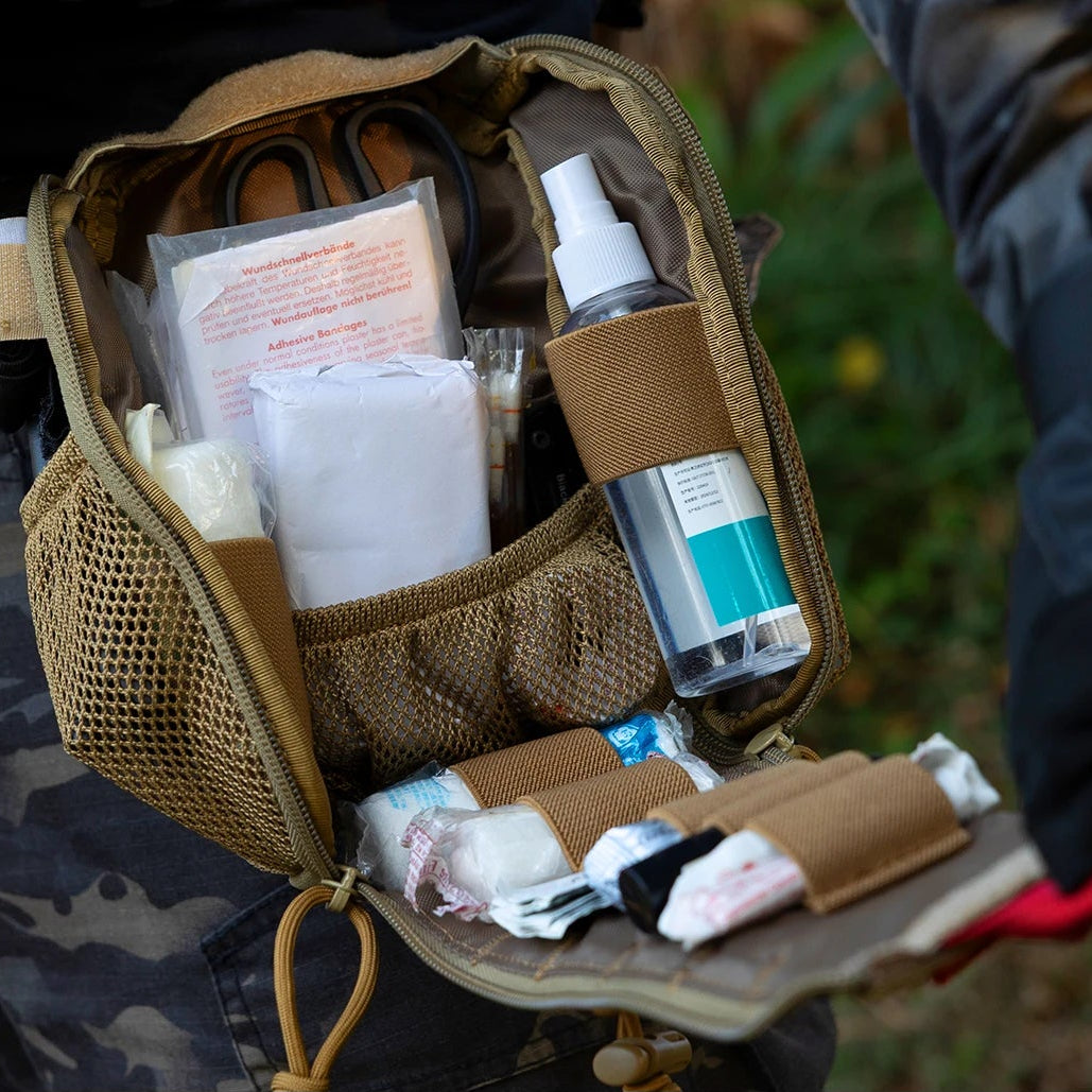 First aid kit in a tactical pouch with text about extreme-duty construction and product features.