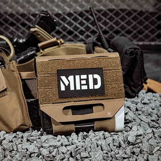 Tactical vest with 'MED' patch on a rocky surface