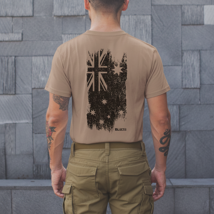 A person wearing a beige T-shirt with a distressed Australian flag design on the back.