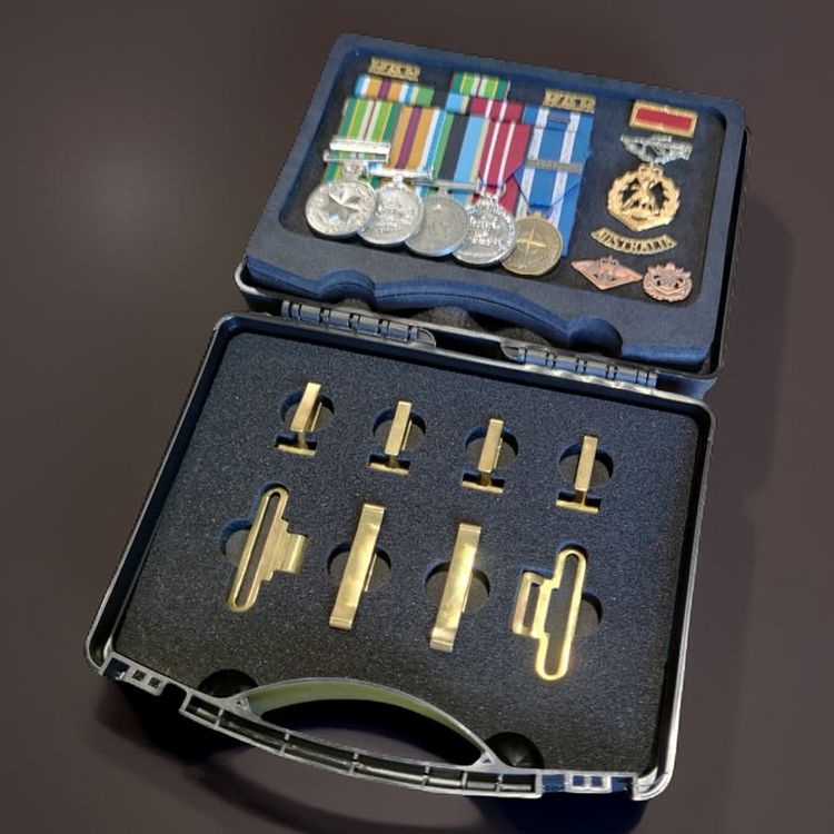 Collection of medals and ribbons in a display case on a dark background